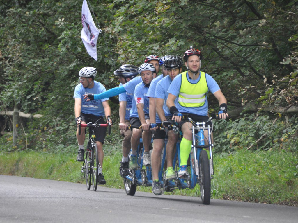 TanDam: the team riding the six-man tandem along a country road