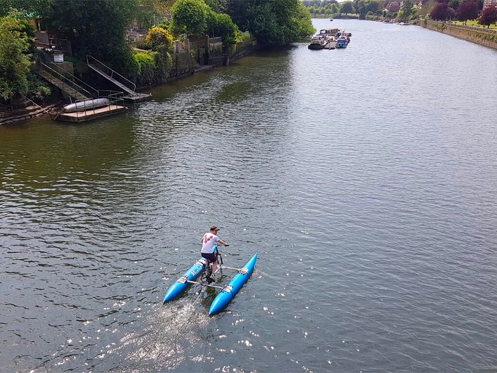 Three Lakes Challenge: a bike fixed to a twin-float water craft, on a river